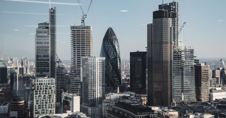 London View - Various shaped modern skyscrapers with glass mirrored facades located in financial district of London against blue sky on sunny day